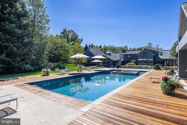 outdoor pool with a lawn, an in ground hot tub, and a residential view