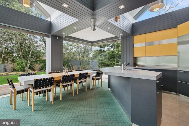 view of patio with outdoor wet bar, a sink, and fence