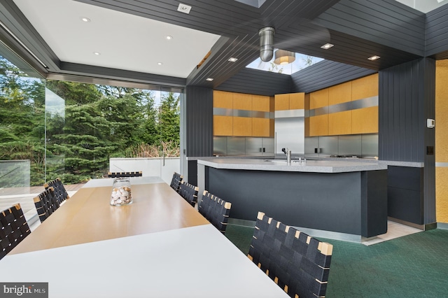 kitchen with light countertops, a sink, modern cabinets, and a wealth of natural light