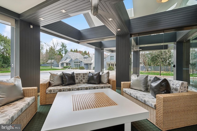 sunroom featuring a skylight, outdoor lounge area, and a wealth of natural light