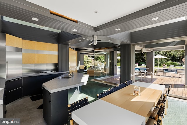 interior space featuring a sink, dark cabinets, tile patterned floors, an island with sink, and modern cabinets