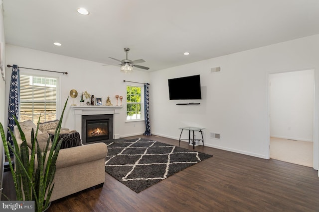 living room featuring visible vents, wood finished floors, and a healthy amount of sunlight