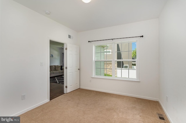 carpeted spare room with baseboards and visible vents