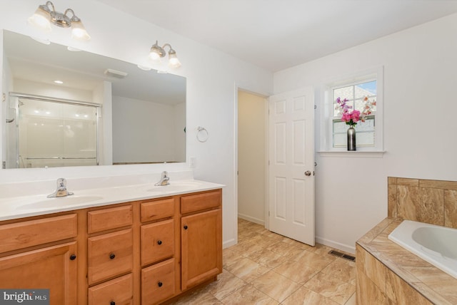 full bathroom with visible vents, a sink, a garden tub, and double vanity