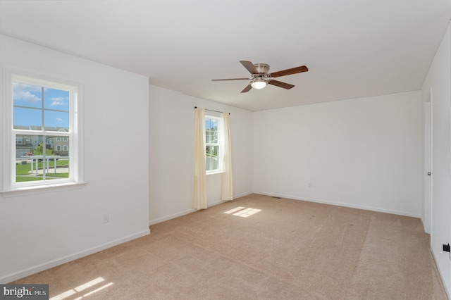 unfurnished room featuring ceiling fan, light carpet, and baseboards