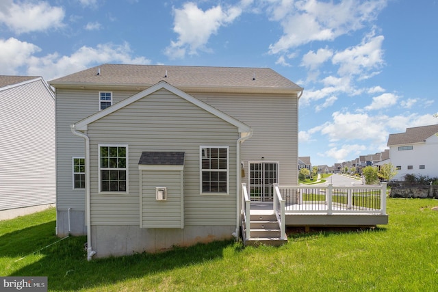 back of property featuring a lawn, a residential view, and a deck