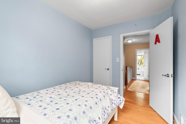 bedroom featuring baseboards and light wood finished floors