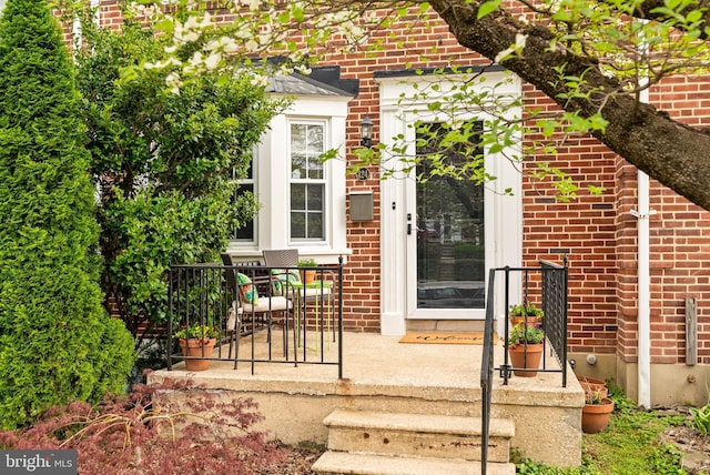view of exterior entry featuring brick siding