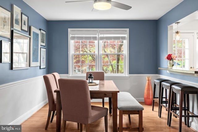 dining area featuring baseboards, ceiling fan, wood finished floors, and a wealth of natural light