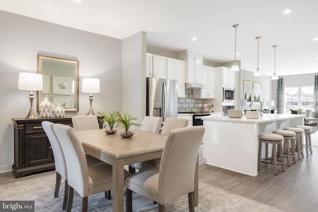 dining room featuring light wood finished floors and recessed lighting