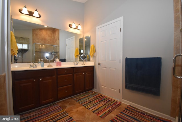 full bath featuring a sink, a stall shower, tile patterned flooring, and double vanity