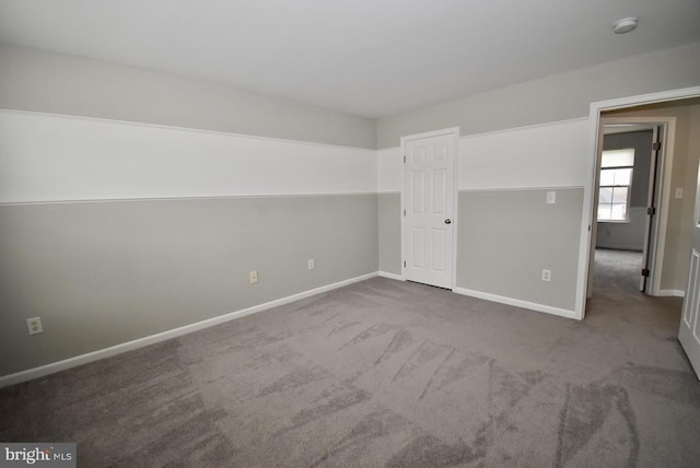 unfurnished bedroom featuring carpet and baseboards