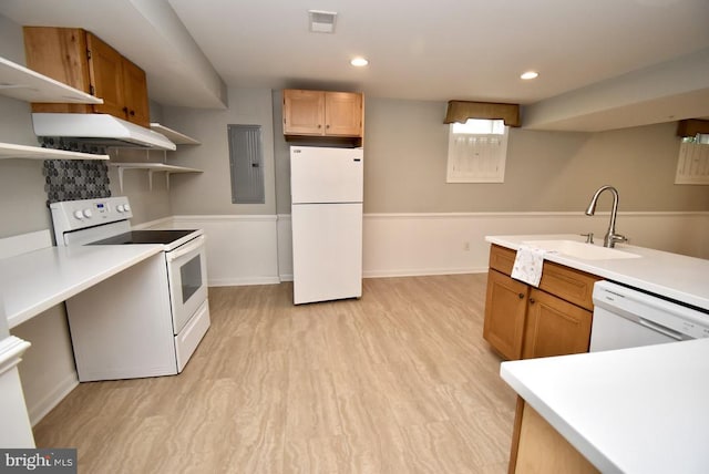 kitchen featuring white appliances, light wood-style flooring, under cabinet range hood, light countertops, and a sink