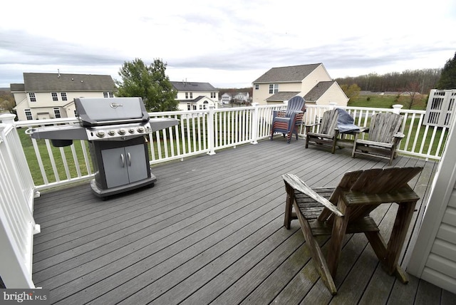 wooden deck featuring a lawn and grilling area