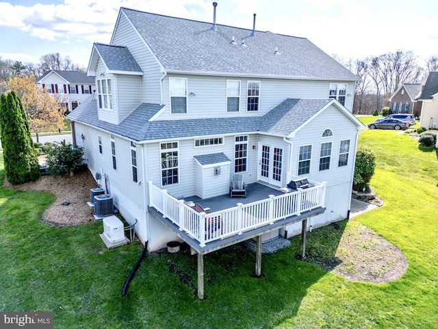 back of property featuring a wooden deck, roof with shingles, central AC, french doors, and a lawn