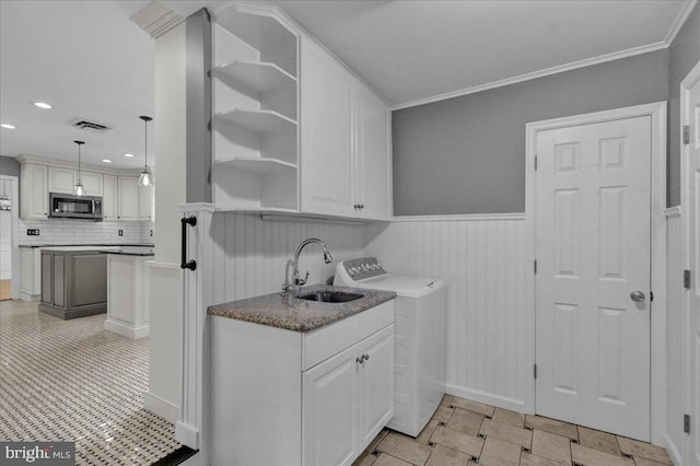 clothes washing area with a sink, visible vents, recessed lighting, cabinet space, and wainscoting