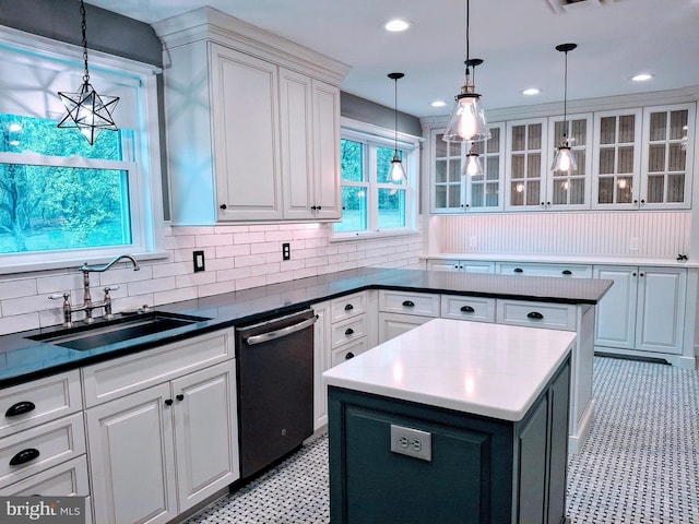 kitchen featuring a sink, dishwashing machine, and white cabinets