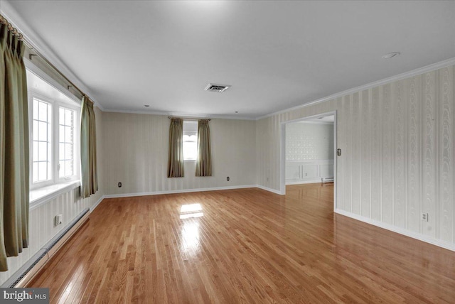 unfurnished room featuring a baseboard radiator, wallpapered walls, light wood finished floors, visible vents, and crown molding