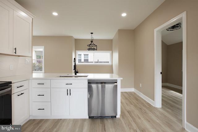 kitchen with a sink, a peninsula, light wood-style flooring, and dishwasher