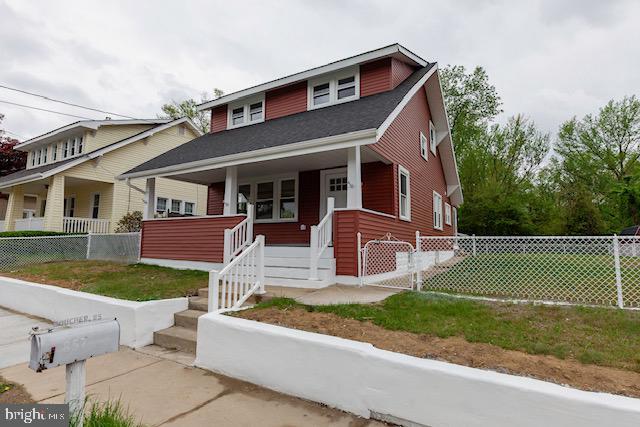 bungalow-style home with a porch and fence
