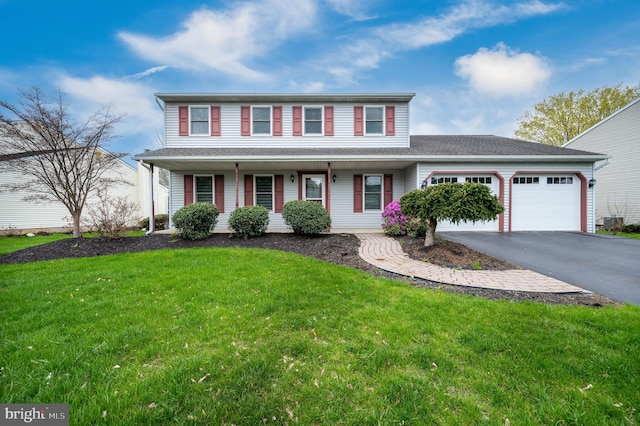view of front of home with a porch, a garage, aphalt driveway, and a front yard