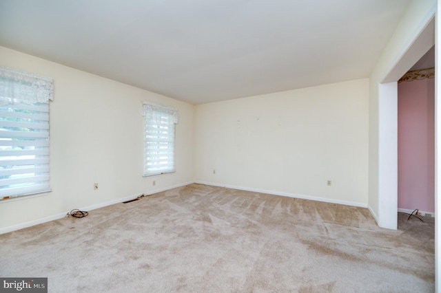 spare room featuring baseboards and carpet
