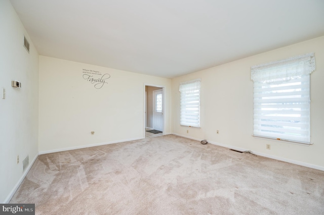 empty room featuring baseboards, carpet flooring, and visible vents