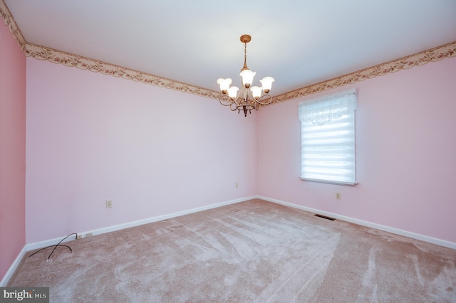 empty room featuring an inviting chandelier, carpet flooring, and baseboards