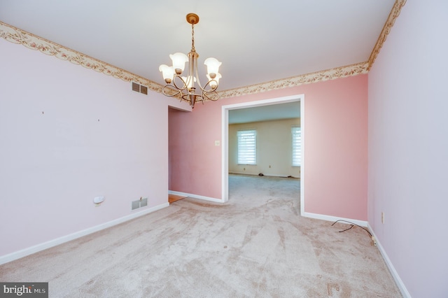 empty room featuring carpet floors, a chandelier, baseboards, and visible vents