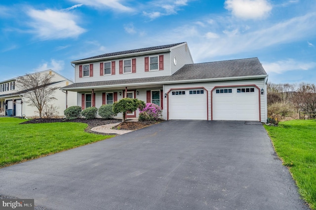 view of front of house with a garage, covered porch, a front yard, and aphalt driveway