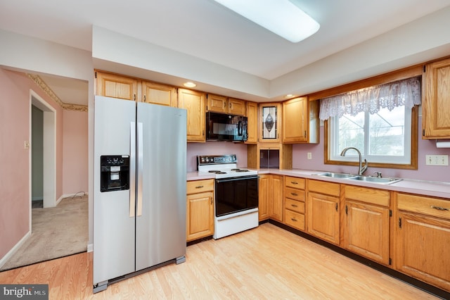 kitchen featuring black microwave, a sink, light wood finished floors, stainless steel fridge with ice dispenser, and white electric range