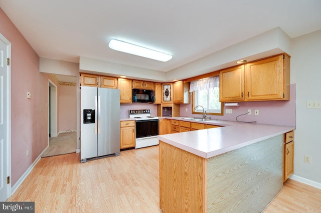 kitchen with black microwave, light wood-type flooring, a sink, stainless steel fridge, and white range with electric stovetop