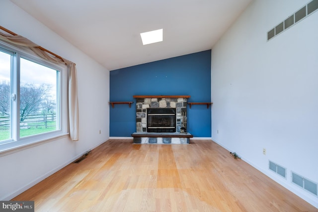 living room featuring visible vents, wood finished floors, and vaulted ceiling