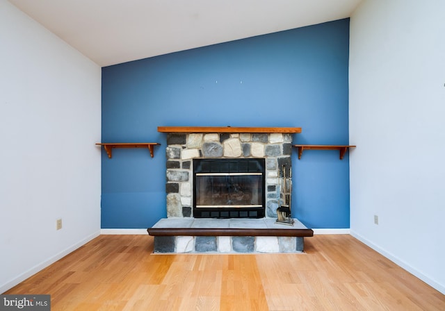 details featuring baseboards, a fireplace, and wood finished floors