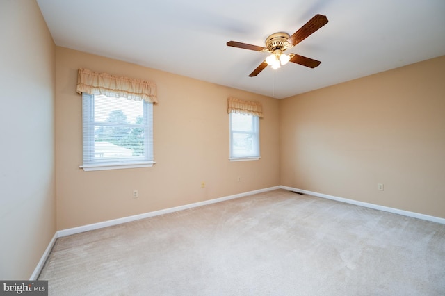 empty room featuring baseboards, a ceiling fan, visible vents, and light carpet