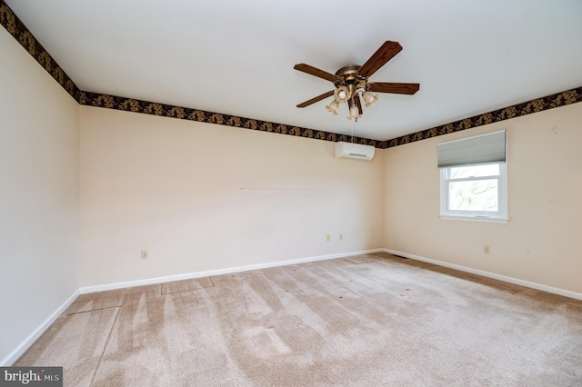 spare room featuring carpet flooring, ceiling fan, baseboards, and a wall mounted air conditioner