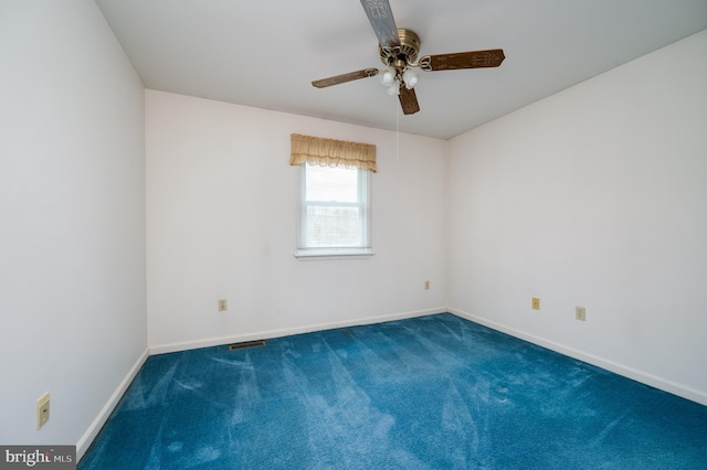 carpeted empty room featuring baseboards, a ceiling fan, and visible vents