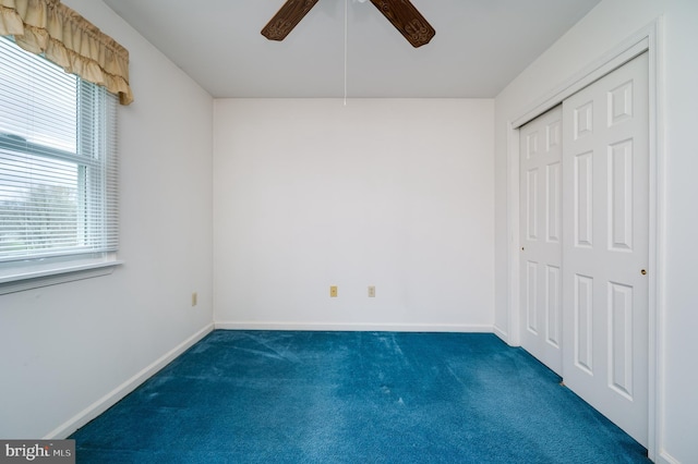 unfurnished bedroom featuring carpet floors, baseboards, multiple windows, and a closet