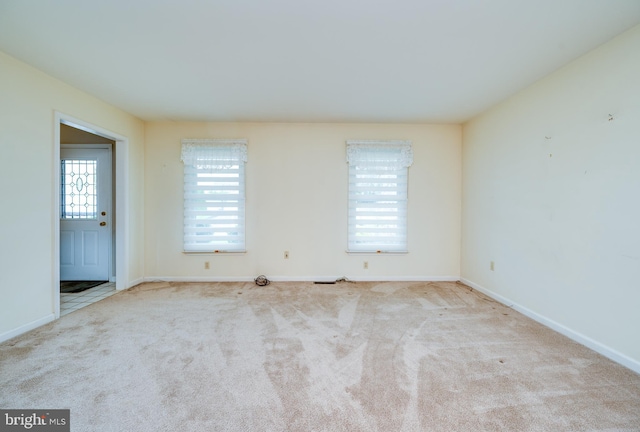 carpeted spare room with baseboards