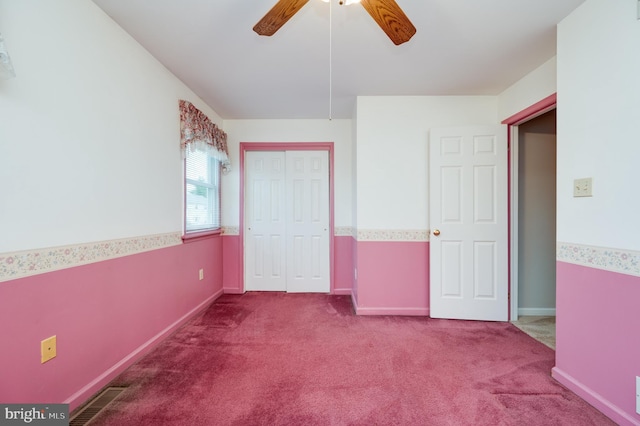 unfurnished bedroom with carpet flooring, ceiling fan, baseboards, visible vents, and a closet