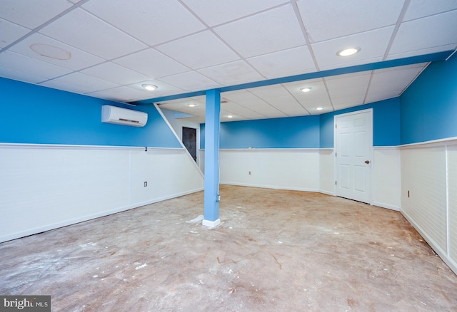 finished basement with recessed lighting, a wall mounted AC, a paneled ceiling, and a wainscoted wall