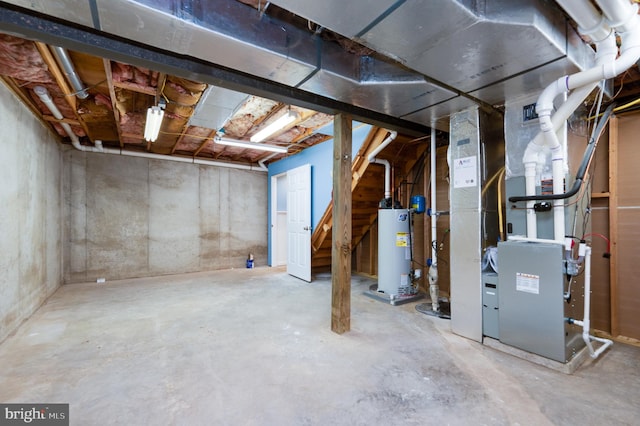 unfinished below grade area featuring heating unit and water heater