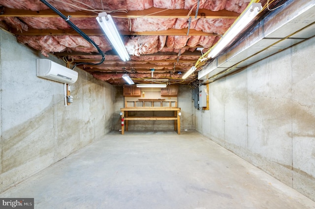 unfinished basement featuring a wall mounted AC and electric panel