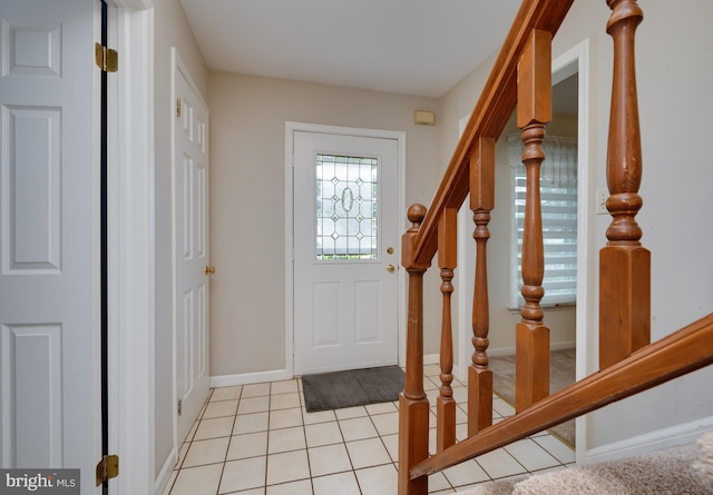 foyer with baseboards, stairs, and light tile patterned floors