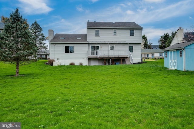 back of property featuring a lawn, a wooden deck, and a chimney