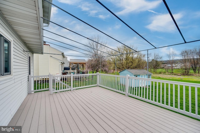 wooden terrace with a lawn, an outdoor structure, and a playground