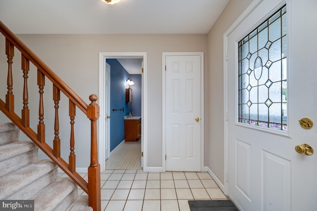 entrance foyer featuring stairway, baseboards, and light tile patterned flooring