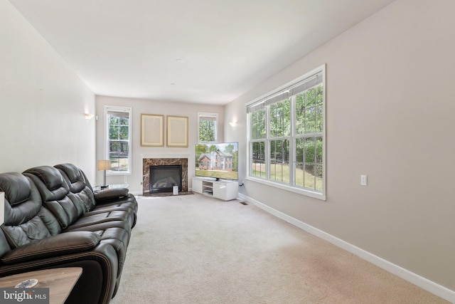 carpeted living room with baseboards and a premium fireplace