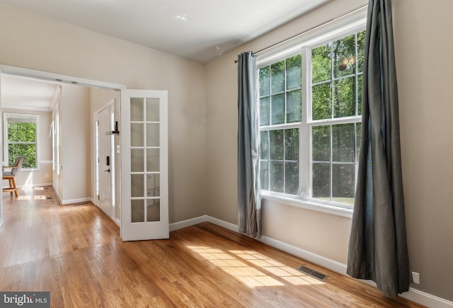empty room with baseboards, visible vents, and light wood-style flooring