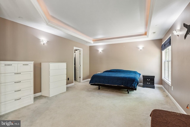 bedroom with a walk in closet, a tray ceiling, light carpet, and baseboards